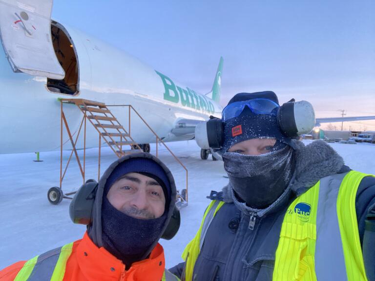 two people posing in front of aircraft