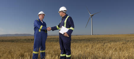 engineer shaking hands with a customer in an open field