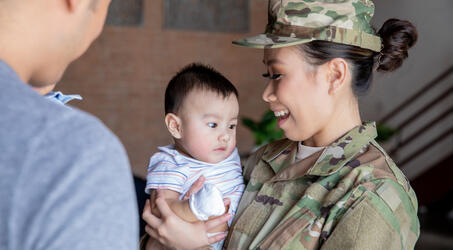  Soldier embraces her husband and two young sons before leaving for military duties 