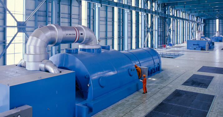 Technician standing in front of gigantic power generator