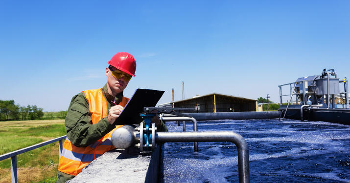 Engineer over Water tank taking measurements