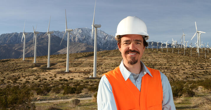 engineer smiling in an open windmill field