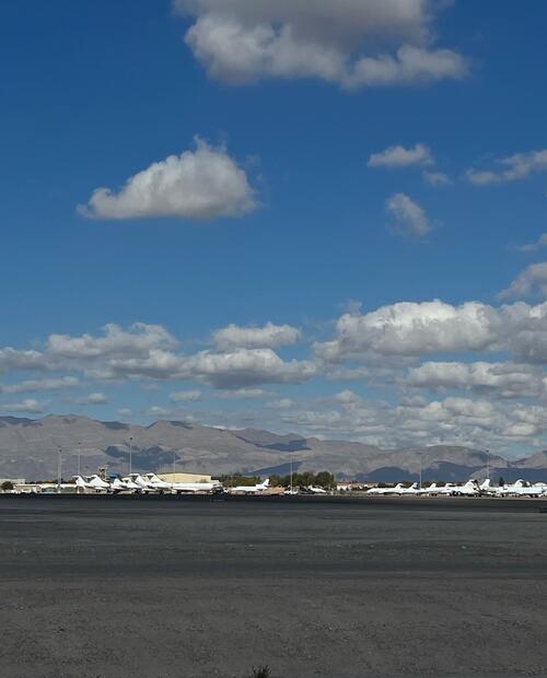 airplanes on runway with mountains in background